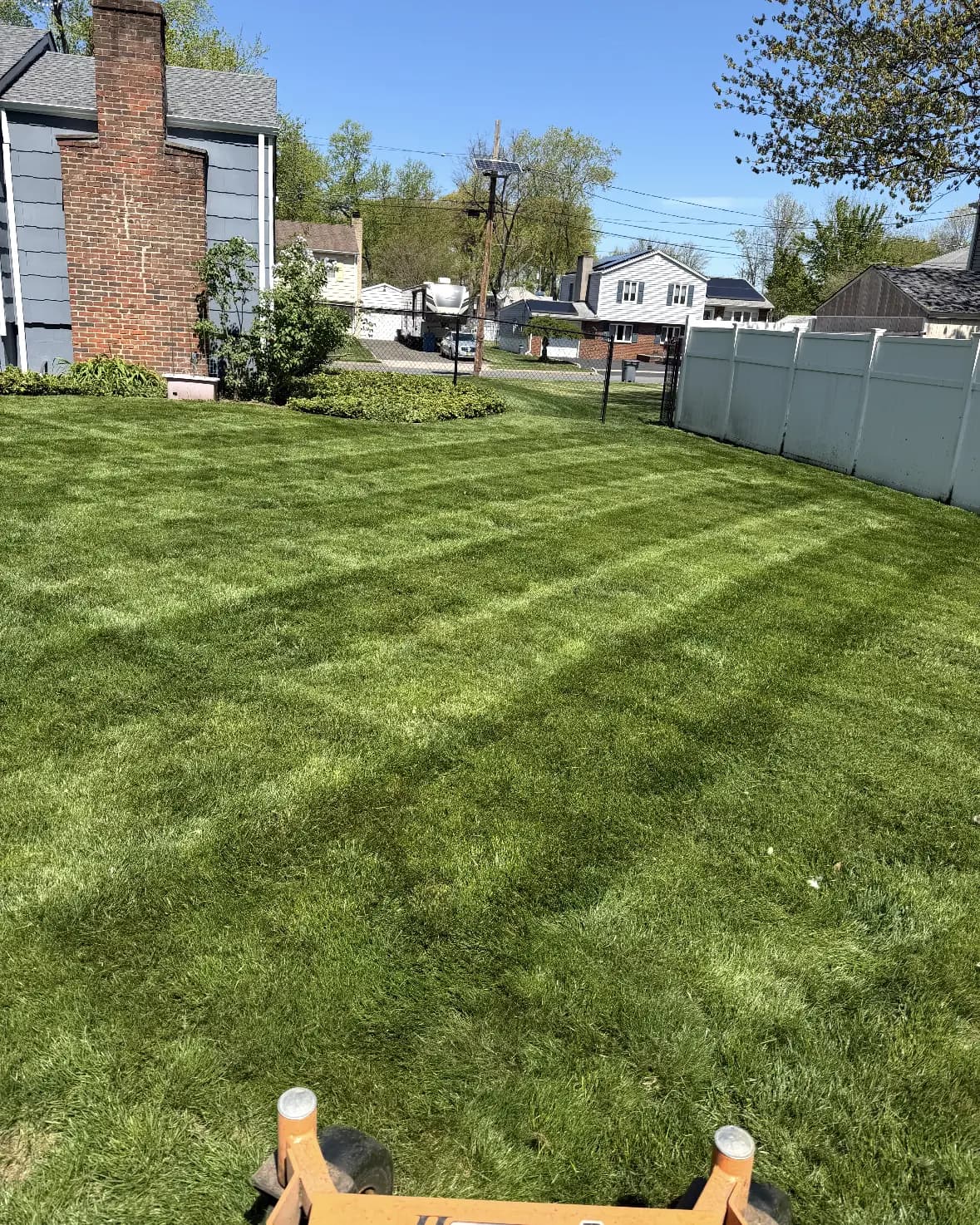 Crisp diagonal stripes across a backyard lawn