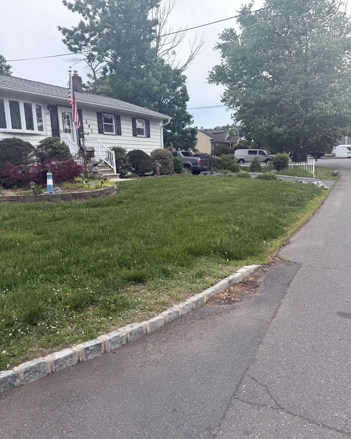 A corner lot lawn with a stone curb border